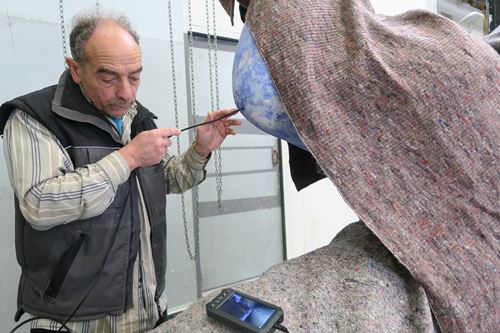 Gérard Haligon utilisant un endoscope pour contrôler l'état de l'intérieur d'une sculpture